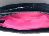 a black purse with a pink lining on it