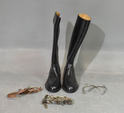 une paire de bottes en cuir noir ornées de garnitures dorées et une paire de chaussures ornées de garnitures dorées
