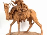 statue of a man riding a camel with a child on his back