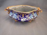a blue and gold bowl with a swan design on it