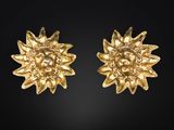 une paire de boucles d'oreilles en forme de tournesol plaquées or sur fond noir