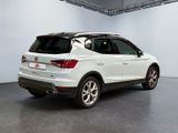 the rear end of a white volkswagen suv parked in a garage