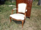 une chaise posée dans l'herbe à côté d'une commode
