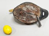 a piece of wood with a knife and a lemon on it