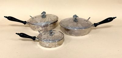trois casseroles et poêles posées sur une table