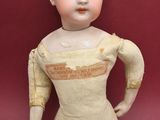 a small doll that is sitting on a red surface