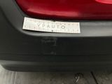 the back end of a red car with a sticker on it