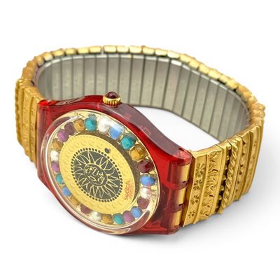 a red and gold watch on a white surface