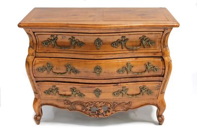 une commode en bois dont les tiroirs sont ornés de sculptures élaborées