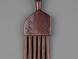 a wooden comb that has a face on it