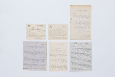 plusieurs morceaux de vieux papier portant des inscriptions, posés sur une surface blanche