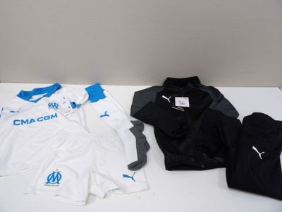 Plusieurs maillots de football sont alignés sur une table blanche