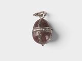 a close up of a pendant on a white surface