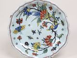 une image représentant une assiette bleue et blanche ornée de fleurs et d'oiseaux