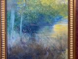 une peinture à l'huile représentant une rivière et des arbres, dans un cadre doré