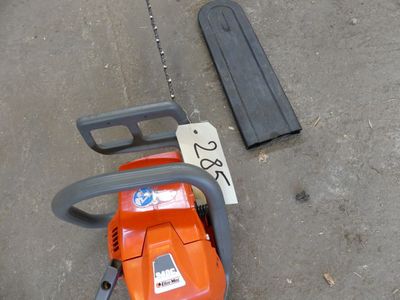 a chainsaw that is laying on the ground next to a piece of wood
