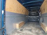 a blue van with a wooden seat in the back of it