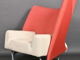 une image représentant une chaise rouge et blanche devant un mur gris