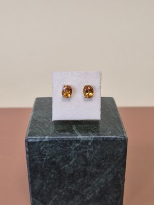 un gros plan sur une paire de boucles d'oreilles posées sur un bloc de marbre