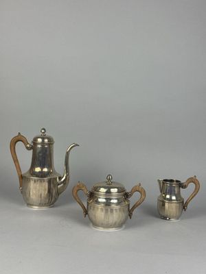 three pieces of silver tea and coffee set on a table