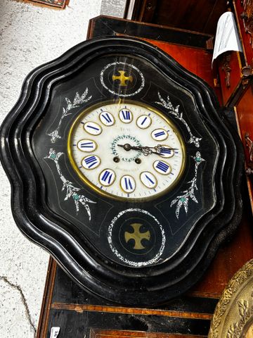 Pendule œil de bœuf en bois noirci incrustation de décor nacré, c...