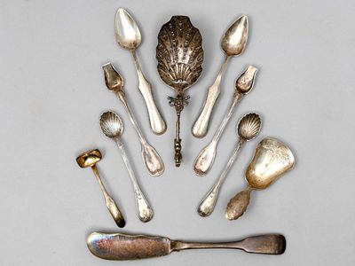 de nombreuses cuillères et cuillères à soupe disposées sur une table