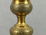 an antique brass vase with a decorative design on the base
