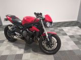 une moto rouge garée sur un sol à damier