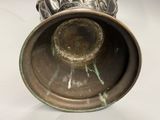 un vase en argent posé sur une table