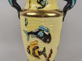 un vase jaune orné de poissons peints