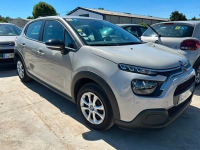 une Citroën argentée garée sur un parking à côté d'autres voitures