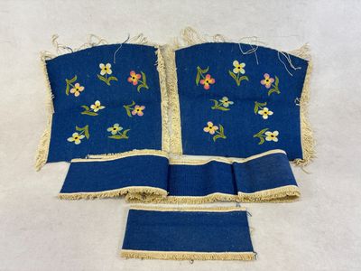 deux morceaux de tissu bleu ornés de fleurs brodées et de franges