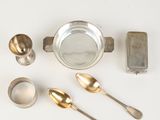 a lot of silver spoons and other silverware on a white surface