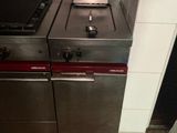 two stainless steel stoves in a kitchen with tile flooring
