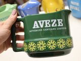 a person holding a green mug with a name on it