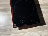 a black stove top sitting on a wooden floor