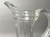 a clear glass pitcher with a handle on a table