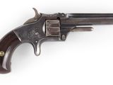 un vieux revolver avec un manche en bois sur fond blanc