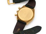 a close up of a watch on a white surface with a black strap