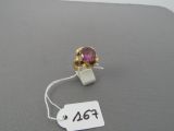 une photo d'une bague avec une pierre rose montée sur un fil