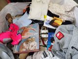 a pile of clothes and books on a bed