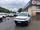 une camionnette blanche garée devant un bâtiment dans un parking