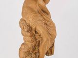 l'image d'une statue de femme assise sur un rocher