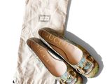 une paire de chaussures Gucci et un sac posés sur une surface blanche