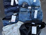 several pairs of women ' s jeans laid out on a table