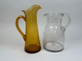 a yellow glass pitcher next to a clear glass pitcher
