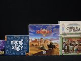 Plusieurs jeux de société sont alignés sur une surface noire