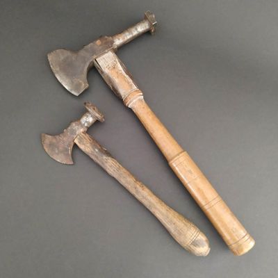 two old axes sitting on top of a table next to each other