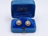 an image of a pair of diamond earrings in a blue velvet box