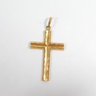 gros plan d'une croix en or sur une surface blanche